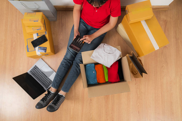 Mulher asiática trabalhando com calculadora, vendendo ideias on-line conceito, loja de negócios vendedor on-line em casa  - Foto, Imagem