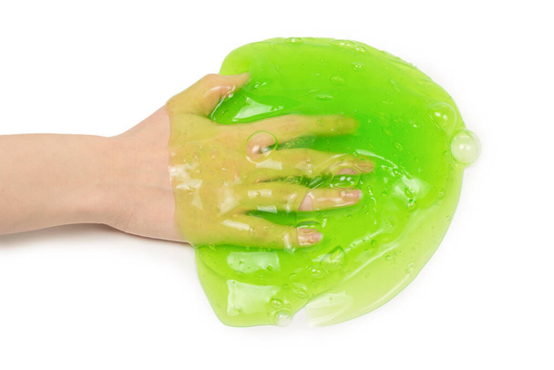 Green slime toy in woman hand isolated on white background. - Photo, Image