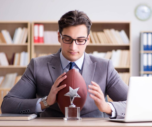 Επιχειρηματίας με αμερικανικό ποδόσφαιρο στο γραφείο - Φωτογραφία, εικόνα