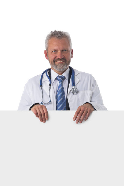 Portrait of a mature caucasian male doctor nurse with blank banner isolated on white background - Fotoğraf, Görsel