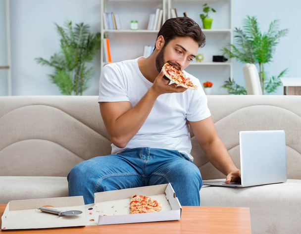Man eating pizza having a takeaway at home relaxing resting - Valokuva, kuva