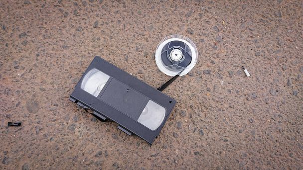 An old broken VHS videotape lies on asphalt - Photo, Image