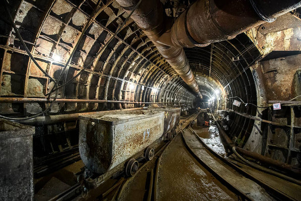 I carrelli si trovano nel profondo tunnel sotterraneo della metropolitana. Costruzione di una linea della metropolitana nella città di Dnipro, Ucraina.  - Foto, immagini