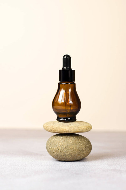 Una bottiglia cosmetica marrone sul podio da pietre naturali. Cosmetici organici naturali, mockup - Foto, immagini