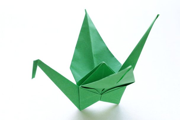 Origami-Vogel aus grünem Papier auf weißem Hintergrund - Foto, Bild