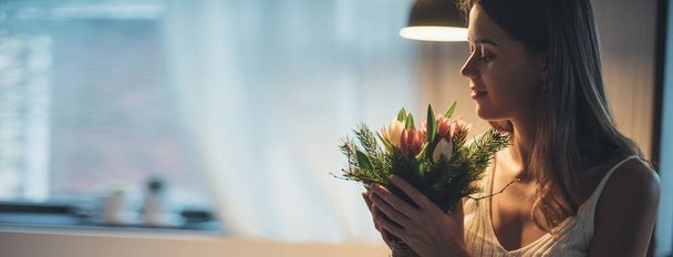 Bouquet primavera di fiori nelle mani di una donna. Giornata internazionale della donna. Una giovane ragazza armeggia nelle mani dei tulipani. - Foto, immagini