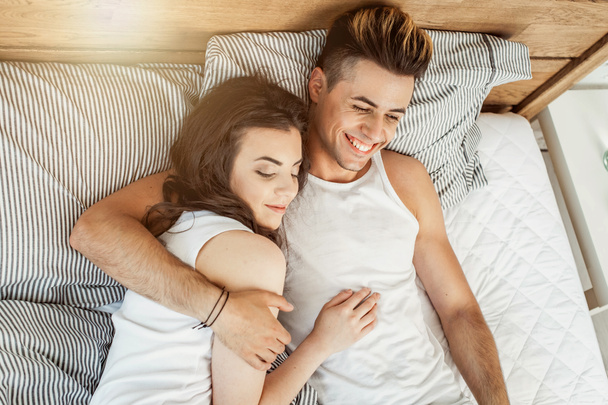 Young loving couple in pajamas in the bed - Photo, Image