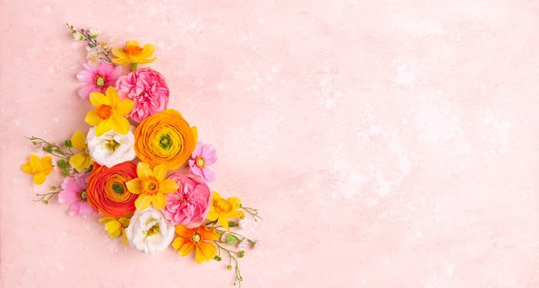 Holiday concept with spring flowers on pastel pink background with copy space for text.  Flat lay pattern. - Valokuva, kuva