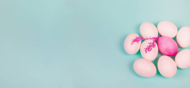 Easter. White eggs with a red egg and a twig on a uniform blue background. Place for text. - Photo, image