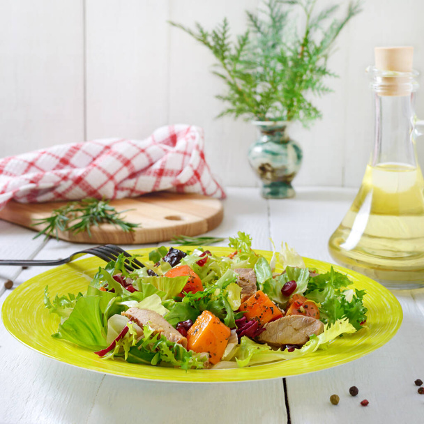 Salade diététique avec dinde rôtie, citrouille et laitue verte sur fond de bois blanc. - Photo, image