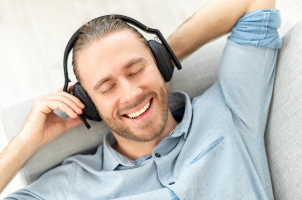 Hipster man in headphones is listening to music - Фото, изображение