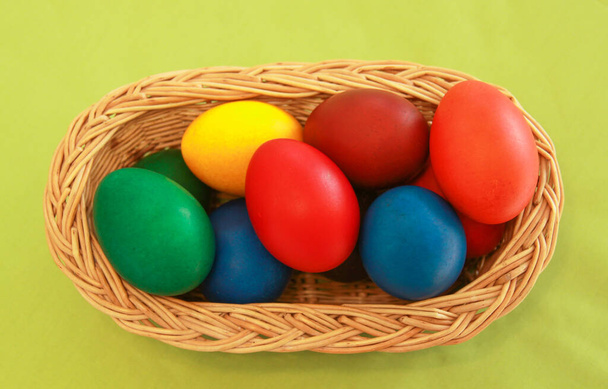 休日の準備のために木製のバスケットの装飾で着色されたイースターの卵を描いた。鶏やアヒルの卵を描くことは、世界中のイースターを祝うキリスト教の伝統です。. - 写真・画像