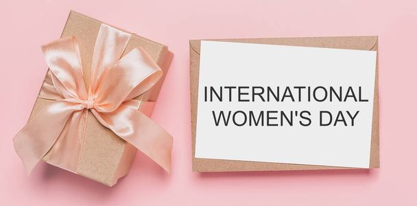 Gifts with note letter on isolated pink background, love and valentine concept with text International Womens Day - Valokuva, kuva