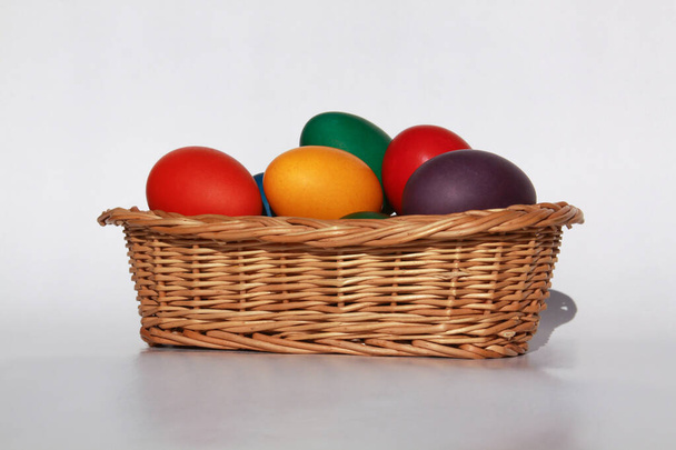 休日の準備のために木製のバスケットの装飾で着色されたイースターの卵を描いた。鶏やアヒルの卵を描くことは、世界中のイースターを祝うキリスト教の伝統です。. - 写真・画像