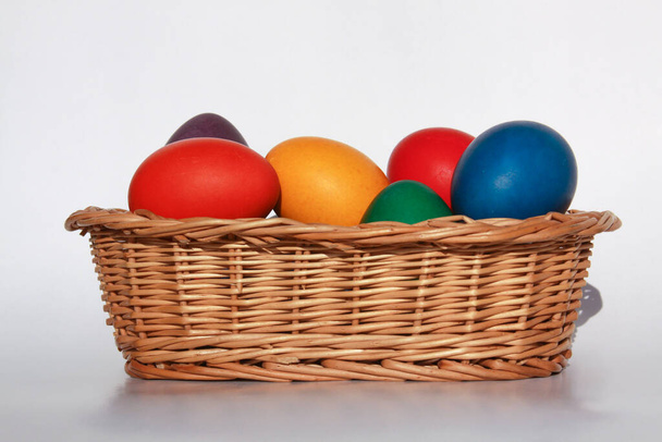 Tatil hazırlığı için ahşap sepet süslemesine boyanmış renkli Paskalya yumurtaları. Tavuk veya ördek yumurtası boyamak tüm dünyada Paskalyayı kutlamak için yapılan bir Hıristiyan geleneğidir.. - Fotoğraf, Görsel
