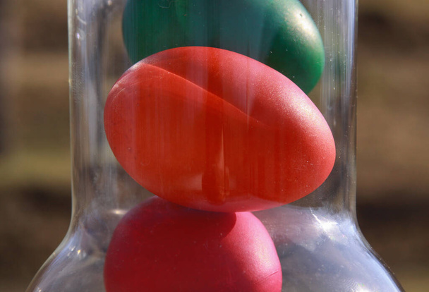 Huevos de Pascua pintados de color en jarrón de vidrio o jarra en preparación para las vacaciones. Pintar huevos de pollo o pato es una tradición cristiana para celebrar la Pascua en todo el mundo. - Foto, imagen