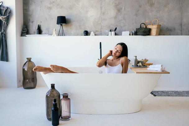 Attractive woman in lingerie posing in the bath - 写真・画像