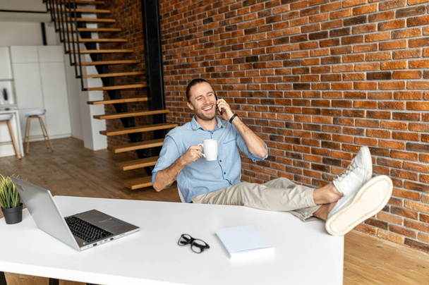 Relaxed entrepreneur sitting in the home office - Photo, Image