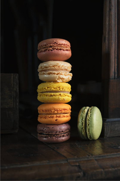 Stack of delicious classic french macaroons or macarons on an old vintage dark sideboard - Valokuva, kuva