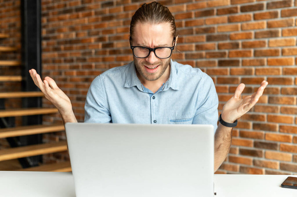 Frustrated young businessman in front of a laptop - Foto, Bild