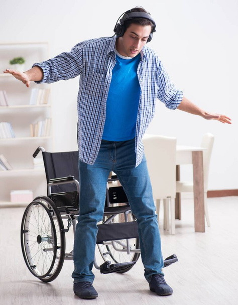 Hombre discapacitado escuchando música en silla de ruedas - Foto, imagen
