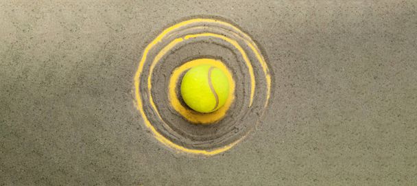 Žlutý tenisový míček na šedém písku se vzorkem. Touha znovu se spojit s přírodou nebo zenovou meditací. Detailní záběr - Fotografie, Obrázek