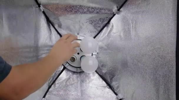 screw a light bulb into a softbox close up - Footage, Video