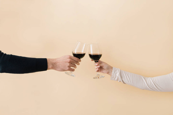 Hands of man and woman toast glasses with red wine.Minimal love valentine concept. - Photo, image