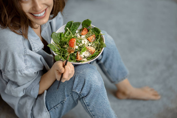 Mujer con ensalada saludable en la cocina - Foto, Imagen
