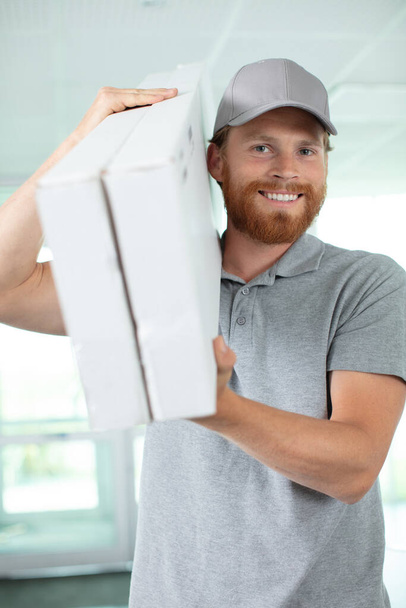 man worker is carrying a box - Fotó, kép