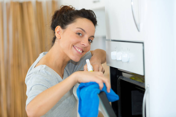 woman cleaning oven with rag - Φωτογραφία, εικόνα