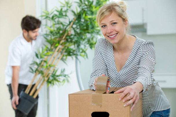 woman closing boxes to move to her new house - Foto, Imagem