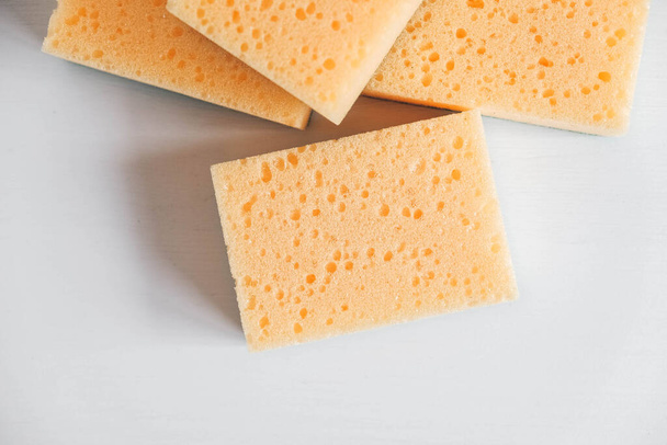 Yellow porous sponges on a white background. Copy, empty space for text. - Photo, Image