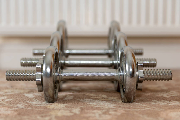 Close up of a row dumbbells on the floor at home - Photo, Image