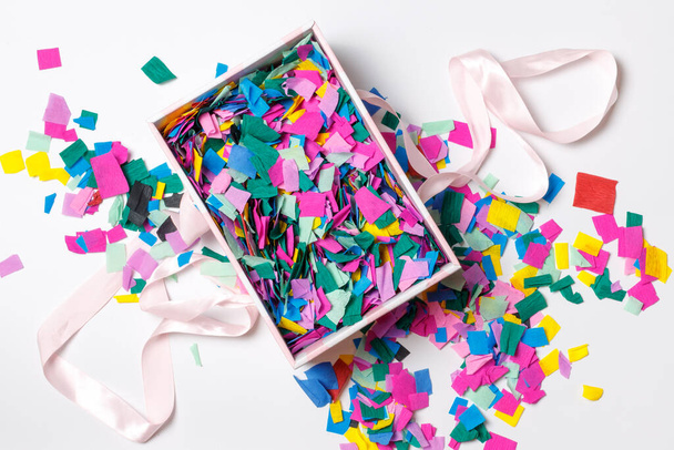 Een geschenkdoos met kleurrijke confetti. Het uitzicht vanaf de top. Close-up - Foto, afbeelding