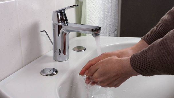 Persona irriconoscibile lavarsi accuratamente le mani a casa per la sicurezza sanitaria - Foto, immagini