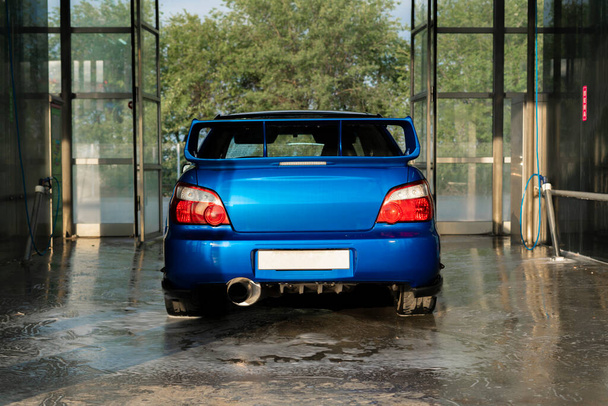 coche deportivo azul dentro de la caja de la estación de auto lavado - Foto, imagen