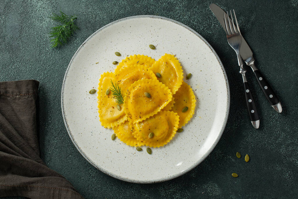 Homemade Pumpkin Ravioli with butter on a dark concrete background. Top view. - Photo, Image