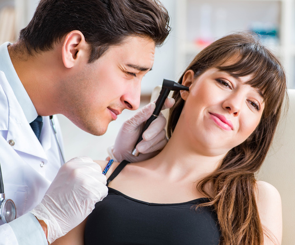 Doktor muayene sırasında hastaların kulaklarını kontrol ediyor. - Fotoğraf, Görsel