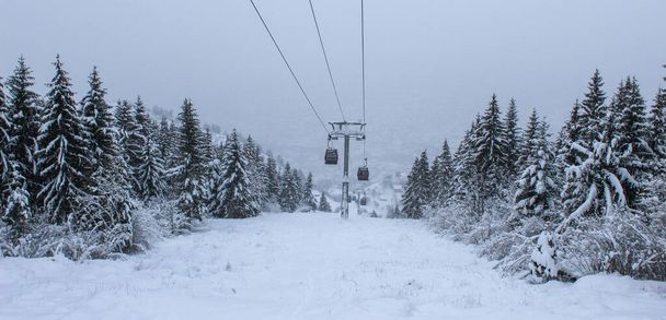 Banner. Teleférico fotografiado desde Trebevic en invierno mientras nieva. Nieve en invierno en la montaña Trebevic. Teleférico de Sarajevo en la naturaleza. Invierno y nieve. - Foto, Imagen