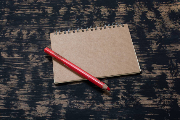Karanlık bir arkaplanda defter ve kalemler - Fotoğraf, Görsel