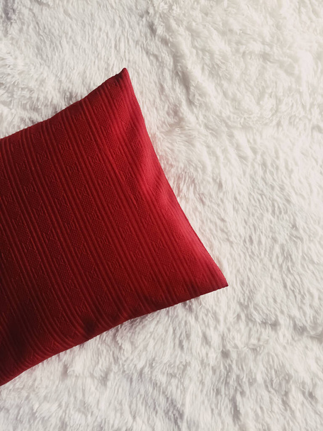 Красные подушки накидывают на белое пушистое одеяло в качестве плоского фона, вида сверху спальни и домашнего декора. - Фото, изображение