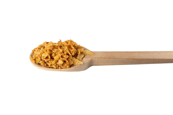 Crujientes copos de cebolla frita carmelizada en cuchara de madera aislada sobre fondo blanco. Especias e ingredientes alimentarios. - Foto, Imagen