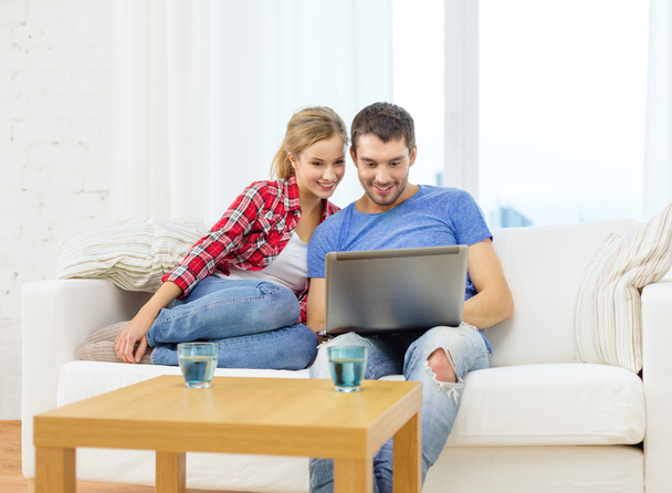 Smiling couple with laptop computer at home - Photo, Image