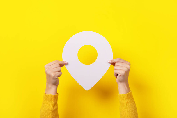 blanco mapa puntero 3d pin en la mano sobre fondo amarillo - Foto, Imagen