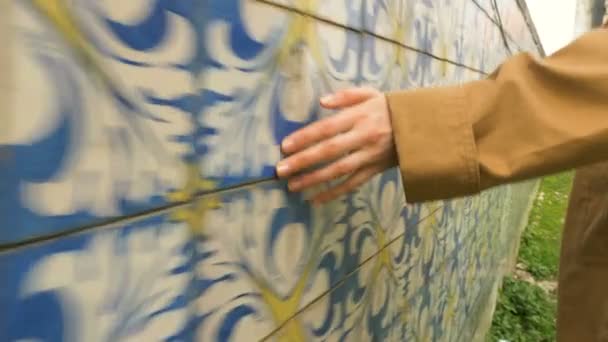 chica en gabardina corre mano sobre azulejo en Lisboa Portugal, cámara lenta - Metraje, vídeo