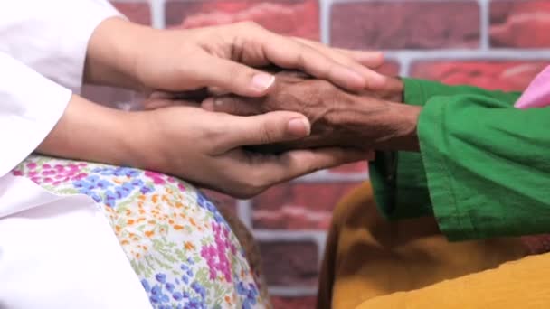 detalhe de mulheres médicos mão segurando mão de mulheres seniores  - Filmagem, Vídeo