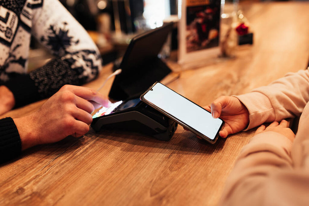 Bezhotovostní platba s NFC a telefonem v kavárně terminálu. Rozmazané pozadí - Fotografie, Obrázek