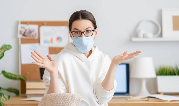 Woman in facemask working in home office. - Zdjęcie, obraz