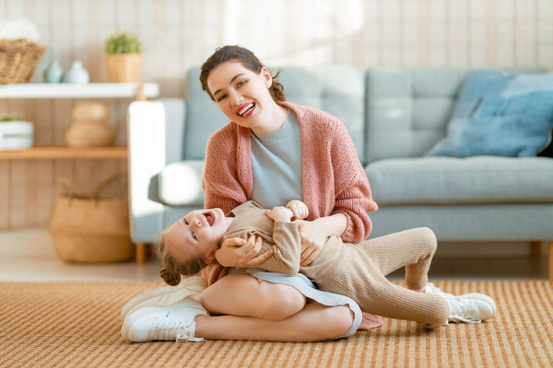 Mom and her daughter child girl are playing, smiling and hugging at home.  - Φωτογραφία, εικόνα